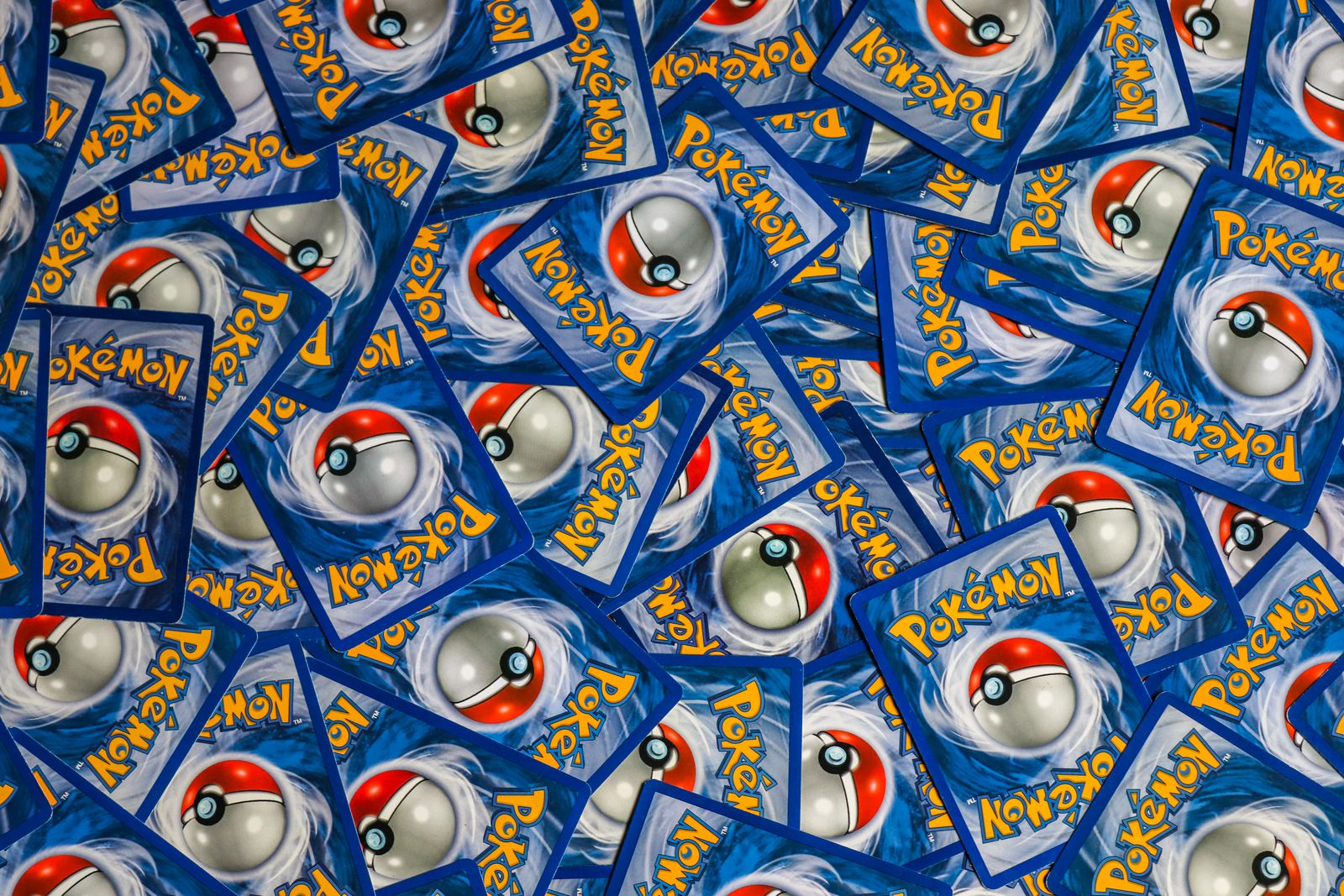 Pokémon cards spread out face down, filling the frame